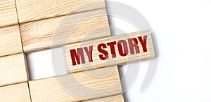 On a light background, wooden blocks with the text MY STORY. Close-up top view