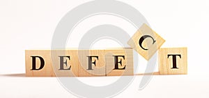 On a light background, wooden cubes with the text DEFECT