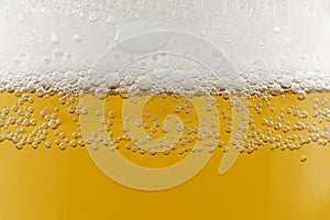 Light beer with foam close-up. Beer yellow background or texture