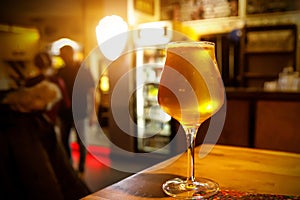 Light beer in a glass, interior pub on the background.