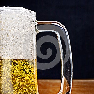 Light Beer in a glass pint mug served on a wooden