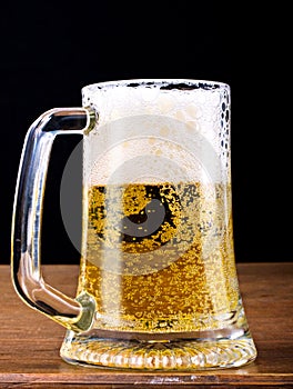 Light Beer in a glass pint mug served on a wooden