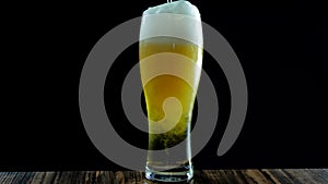 Light beer is poured into a beer glass on a black background,close-up of beer in a glass-
