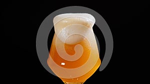Light beer is pouring into glass. IPA. Cold Light Beer in a glass with water drops. Craft Beer forming foam close up.