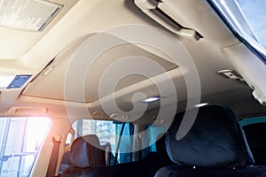 Light beige ceiling in the cabin of the SUV after dry cleaning and seasonal inspection in the workshop for repair and maintenance