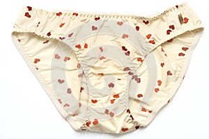 A light beige colored woman panties with small orange and brown heart printings