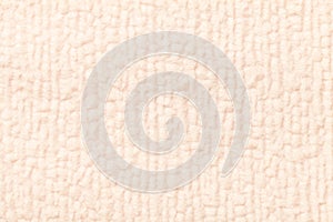 Light beige fluffy background of soft, fleecy cloth. Texture of textile closeup.