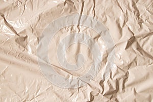Light beige glossy crumpled film as background