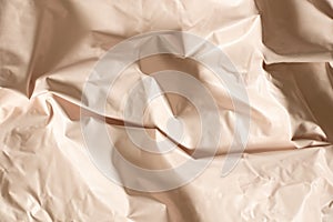 Light beige glossy crumpled film as background