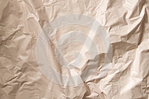 Light beige glossy crumpled film as background