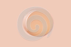 Light beige liquid makeup smear of creamy luminous blusher on beige background.