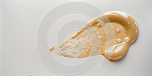 Light beige makeup smear of creamy foundation on white background.