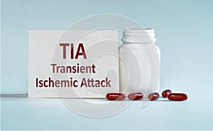On a light blue background a card with the text TIA - Transient Ischemic Attack near the white bottle pills