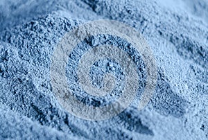 Light blue bentonite facial clay powder alginate mask, body wrap texture close up, selective focus. Abstract background photo
