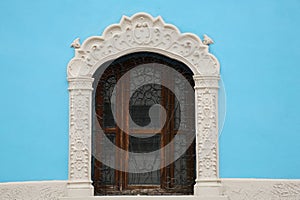 Light blue building with beautiful window and steel grilles