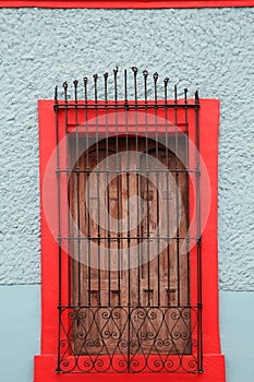 Light blue building with window and steel grilles