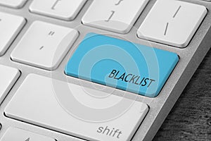 Light blue button with word Blacklist on computer keyboard, closeup