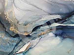 Light blue and dark blue abstract backgroud made with alcohol ink and gold pigment