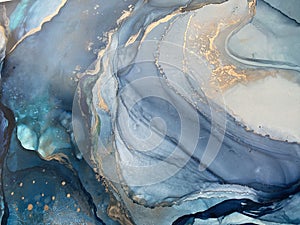 Light blue and dark blue abstract backgroud made with alcohol ink and gold pigment