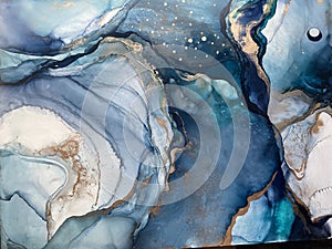 Light blue and dark blue abstract backgroud made with alcohol ink and gold pigment