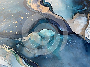 Light blue and dark blue abstract backgroud made with alcohol ink and gold pigment