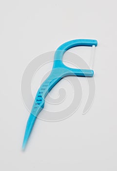 Light blue dental floss pick with flat thread and wide bow for d