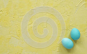 Light blue easter eggs on yellow background.Copy space.Top view.