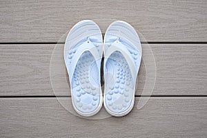 Light Blue Flip Flops on Gray Deck Background