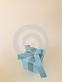 Light Blue gift box on beige background, copy space. Vertical.