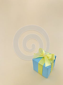 Light blue gift box on beige background . vertical , copy space.