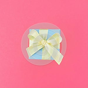 Light blue gift box on bubblegum pink background. square