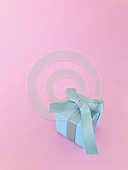 Light Blue gift box on pink background, vertical.