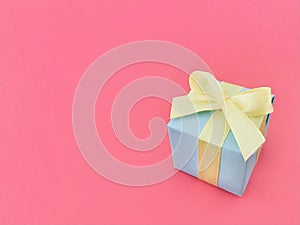 Light blue gift box on watermelon pink background. vertical.