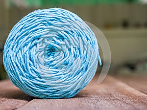 Light blue knitting yarn on wooden background