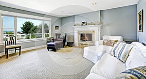 Light blue living room with white sofa and fireplace