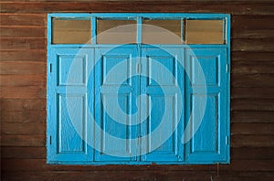 Light blue painted vintage retro wooden windows and panes, home interior architectural design against plain tropical dark brown