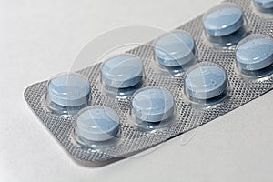 Light blue pills on white background. Pharmaceutical industry, medical treatment, presciption drugs concept