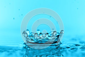 light blue transparent water wave surface with splash bubble on blue