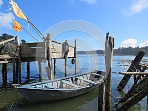 Light blue wooden boat moored to old pier