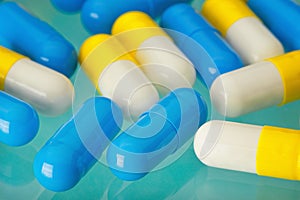 Light blue and yellow pills on a medical table