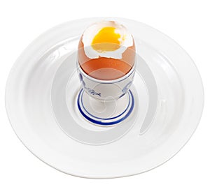 Light boiled egg in egg cup on white plate