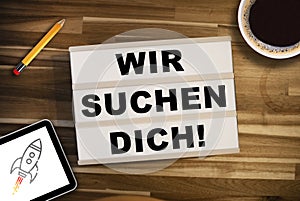 Light box with german words for We are looking for you - Wir suchen dich on a wooden table photo