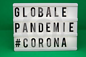 A light box with the inscription: GLOBALE PANDEMIE #CORONA with white background photo