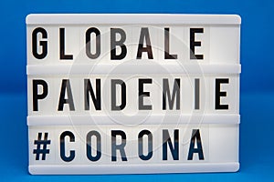 A light box with the inscription: GLOBALE PANDEMIE #CORONA with white background photo