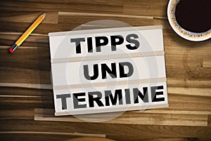 Light box or lightbox on a wooden tablet with the german words for tip and dates upcoming events - Tipps und Termine photo