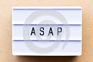 Light box with word ASAP Abbreviation of as soon as possible on wood background