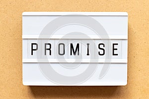 Light box with word promise on wood background