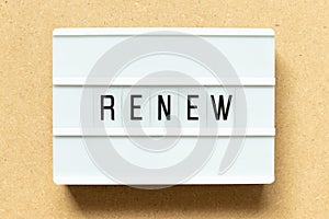Light box with word renew on wood background
