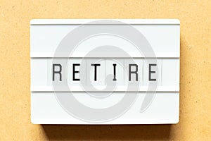 Light box with word retire on wood background