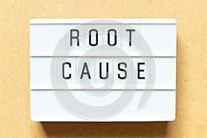 Light box with word root cause on wood background